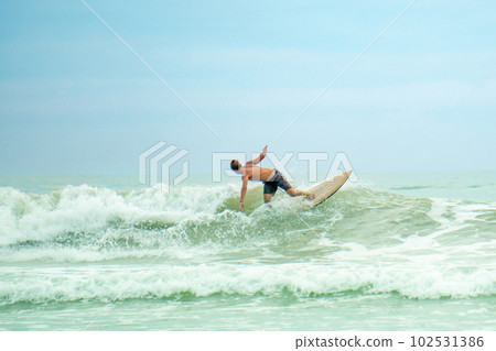professional surfer riding waves in Thailand, men catching waves in ocean,beach swimming activity on summer vacation 102531386