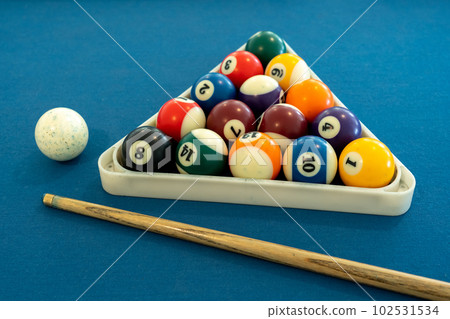 Billiard balls in triangle rack with cues on table at snooker club. Billiard balls in triangle rack with cues on table at snooker club. 102531534