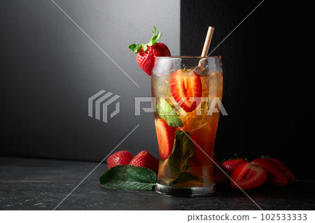 Iced tea or a summer refreshing drink with ice, mint, and strawberries. Iced tea or a summer refreshing drink with ice, mint, and strawberries. 102533333