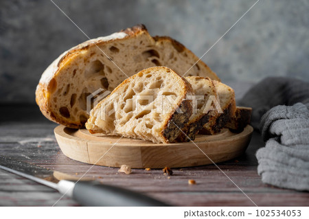 Sourdough homemade bread made from high protein white flour, cut into slices on cutting board.Top view. Sourdough homemade bread made from high protein white flour, cut into slices on cutting board.Top view. 102534053