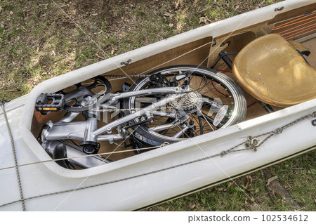 folding bike packed into a cockpit of expedition canoe folding bike packed into a cockpit of expedition canoe 102534612
