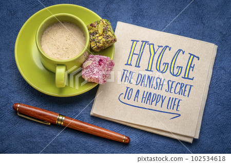 hygge - the Danish secret to a happy life, handwritten note on a napkin with a cup of coffee, lifestyle and cultural concept 102534618