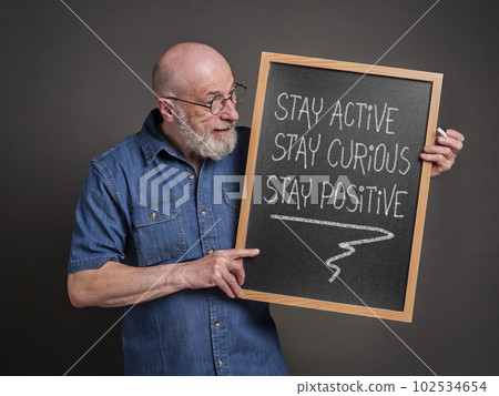 stay active, curious and positive - the keys to healthy aging, inspirational white chalk writing on a blackboard held by a senior man stay active, curious and positive - the keys to healthy aging, inspirational white chalk writing on a blackboard held by a senior man 102534654