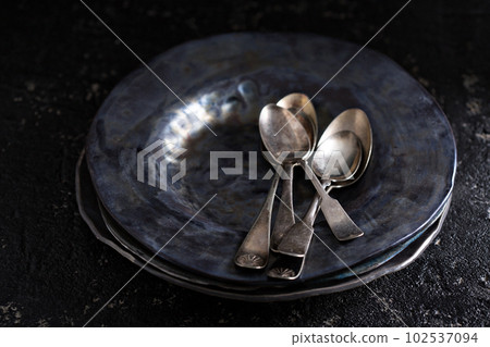 Black handmade ceramic plates with vintage spoons 102537094