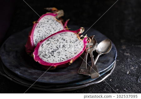 Dragon fruit cut open on a plate Dragon fruit cut open on a plate 102537095
