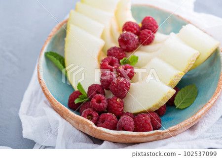 Melon slices served with raspberry and honey Melon slices served with raspberry and honey 102537099