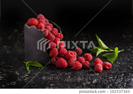 Fresh sweet raspberry in black cup 102537163