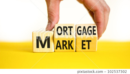 Mortgage market symbol. Concept words Mortgage market on wooden cubes. Beautiful yellow table white background. Businessman hand. Business mortgage market concept. Copy space. Mortgage market symbol. Concept words Mortgage market on wooden cubes. Beautiful yellow table white background. Businessman hand. Business mortgage market concept. Copy space. 102537302