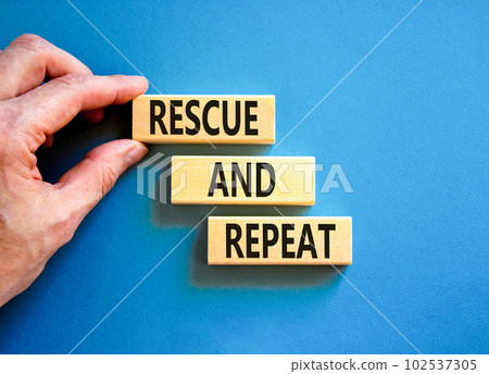 Rescue and repeat symbol. Concept words Rescue and repeat on wooden block on a beautiful blue table blue background. Businessman hand. Business rescue and repeat concept. Copy space. 102537305