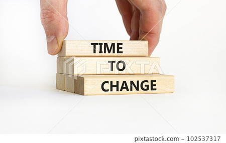 Time to change symbol. Concept words 'Time to change' on wooden blocks. Businessman hand. Beautiful white background. Business and time to change concept. Copy space. Time to change symbol. Concept words 'Time to change' on wooden blocks. Businessman hand. Beautiful white background. Business and time to change concept. Copy space. 102537317