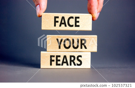 Face your fears and support symbol. Concept words Face your fears on wooden blocks. Businessman hand. Beautiful grey table grey background. Business and Face your fears quote concept. Copy space. 102537321