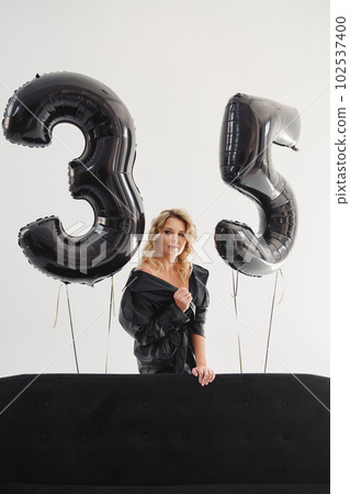 a naked blonde with tattoos in a black coat by a black sofa. birthday a naked blonde with tattoos in a black coat by a black sofa. birthday 102537400