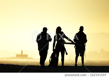 Black silhouettes of youth standing at sunset 102541507
