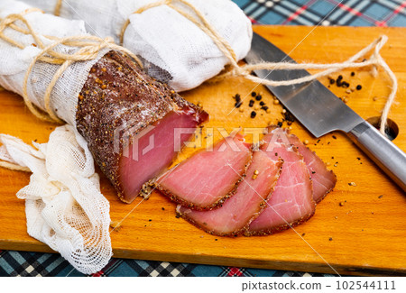 Cured pork meat sliced on wooden board 102544111