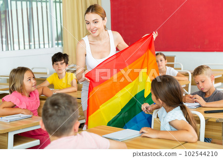 Positive female teacher standing with lgbt flag 102544210