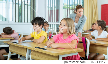 Group of school kids and teacher during lesson in classroom 102544447