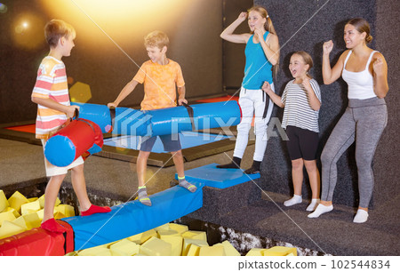 Tween boy having fun on battle beam with friend Tween boy having fun on battle beam with friend 102544834