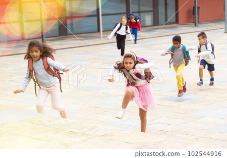 Happy schoolchildren running in the race from school outdoors 102544916