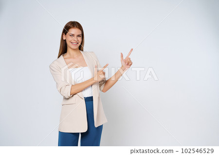 Young woman pointing to empty copy space isolated on white background. Young woman pointing to empty copy space isolated on white background. 102546529