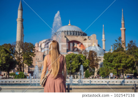 Woman enjoy beautiful view on Hagia Sophia Cathedral, famous islamic Landmark mosque, Travel to Istanbul, Turkey. Sunny day architecture and Hagia Sophia Museum, in Eminonu, istanbul, Turkey. Turkiye Woman enjoy beautiful view on Hagia Sophia Cathedral, famous islamic Landmark mosque, Travel to Istanbul, Turkey. Sunny day architecture and Hagia Sophia Museum, in Eminonu, istanbul, Turkey. Turkiye 102547138