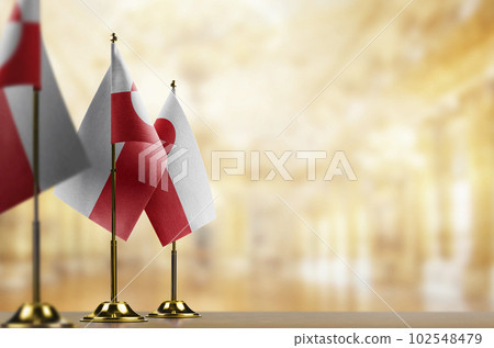 Small flags of the Greenland on an abstract blurry background Small flags of the Greenland on an abstract blurry background 102548479