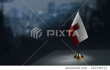 A small Gibraltar flag on an abstract blurry background 102548512