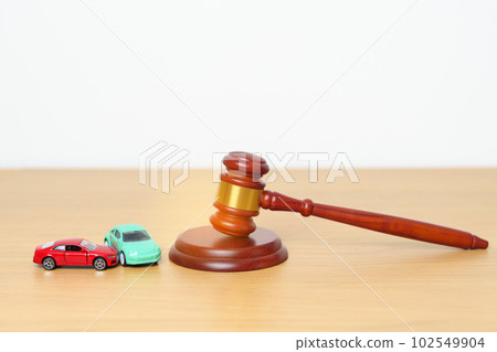 Car Law, Insurance, auto Tax, Auction and Bidding concepts. crashed small toy car models with Judges gavel on desk in courthouse. 102549904