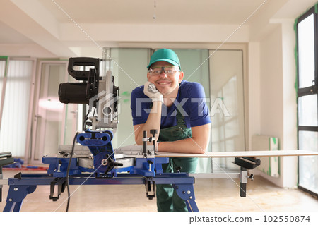 Carpenter working in workshop and looking at camera with gladness Carpenter working in workshop and looking at camera with gladness 102550874