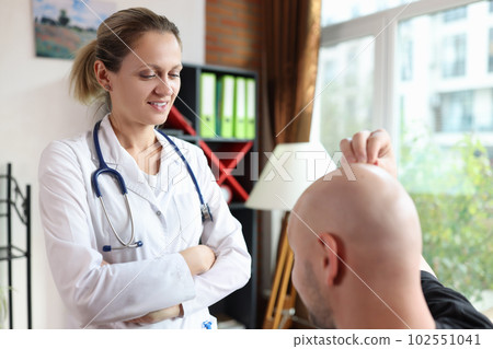 Woman doctor trichologist examining male patient with hair loss problem Woman doctor trichologist examining male patient with hair loss problem 102551041