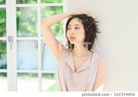 A young woman at the window 102554050