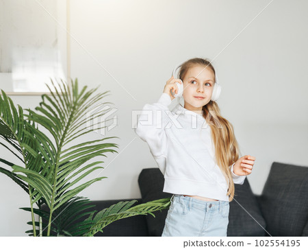 Cute little girl listening to music in headphones Cute little girl listening to music in headphones 102554195
