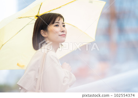 一個在雨中等待的女人 一個拿著雨傘的年輕女人 一個在雨中等待的女人 一個拿著雨傘的年輕女人 102554374