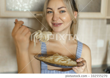 Sexy blonde housewife eating cooked pasta portrait close-up Sexy blonde housewife eating cooked pasta portrait close-up 102555270