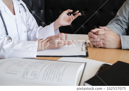 Professional medical doctor in white uniform gown coat interview consulting patient 102557075