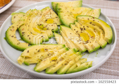 ripe avocado pulp cut into pieces sprinkled with lemon juice on a plate ripe avocado pulp cut into pieces sprinkled with lemon juice on a plate 102558423