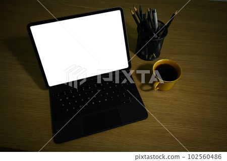 Above view of digital tablet with wireless keyboard, coffee cup and pencil holder on wooden working desk Above view of digital tablet with wireless keyboard, coffee cup and pencil holder on wooden working desk 102560486