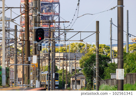 A train running between utility poles and traffic lights 102561341