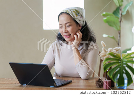 Old woman in summer theme work at cafe using laptop computer. work and travel concept 102562812