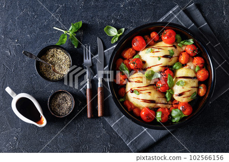 caprese chicken in black baking dish, top view 102566156