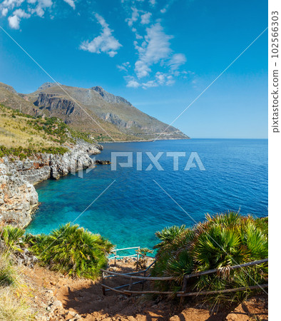 Paradise sea bay with azure water and beach view from coastline trail of Zingaro Nature Reserve Park, between San Vito lo Capo and Scopello, Trapani province, Sicily, Italy. 102566303