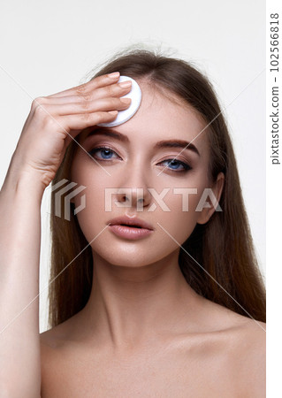 woman holding white cotton pad for removing makeup woman holding white cotton pad for removing makeup 102566818