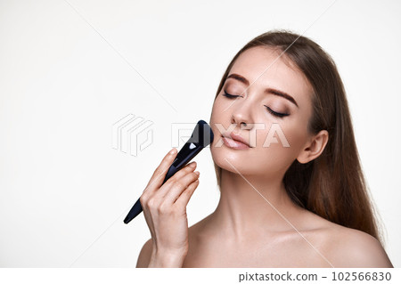 lovely lady posing with make-up brush for powder 102566830