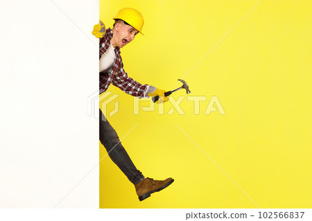 professional builder in work clothes in helmet holding hammer. 102566837