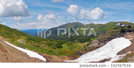 Summer mountain view with snow on mountainside (with observatory ruins on Chornogora Ridge, Ukraine). 102567016