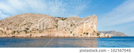 Summer rocky coastline and military base on rock top. Alchak Cape, Sudak Town environs, Crimea, Ukraine. 102567048