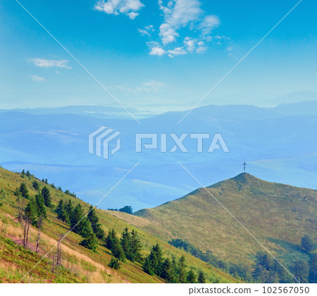 Summer misty mountain landscape with christian cross on top (Ukraine, Carpathian Mountains) 102567050
