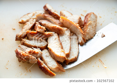 Grilled and sliced chicken breast on white cutting board. Grilled and sliced chicken breast on white cutting board. 102567102