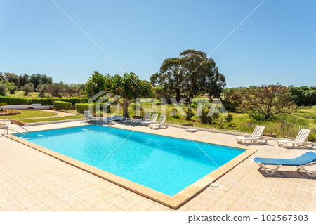 Private swimming pool with sun loungers and garden around. 102567303