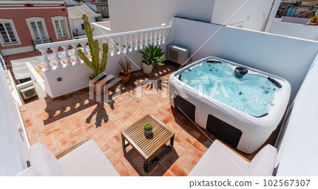 On the terrace of the house there is a modern outdoor Jacuzzi tub for tourists to relax. pots with plants and views of the houses. 102567307