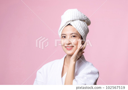 Beautiful young asian woman happy with clean face skin in towel and bathrobe, spa suit on pink background. Skincare, treatment, wellness therapy, facial care, beauty female health, cosmetology concept 102567519